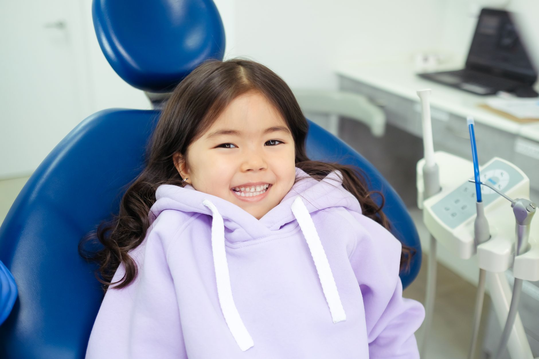 Cheerful child in a dental chair, ready for a dental checkup טיפולי שיניים לילידים ולנוער, ד