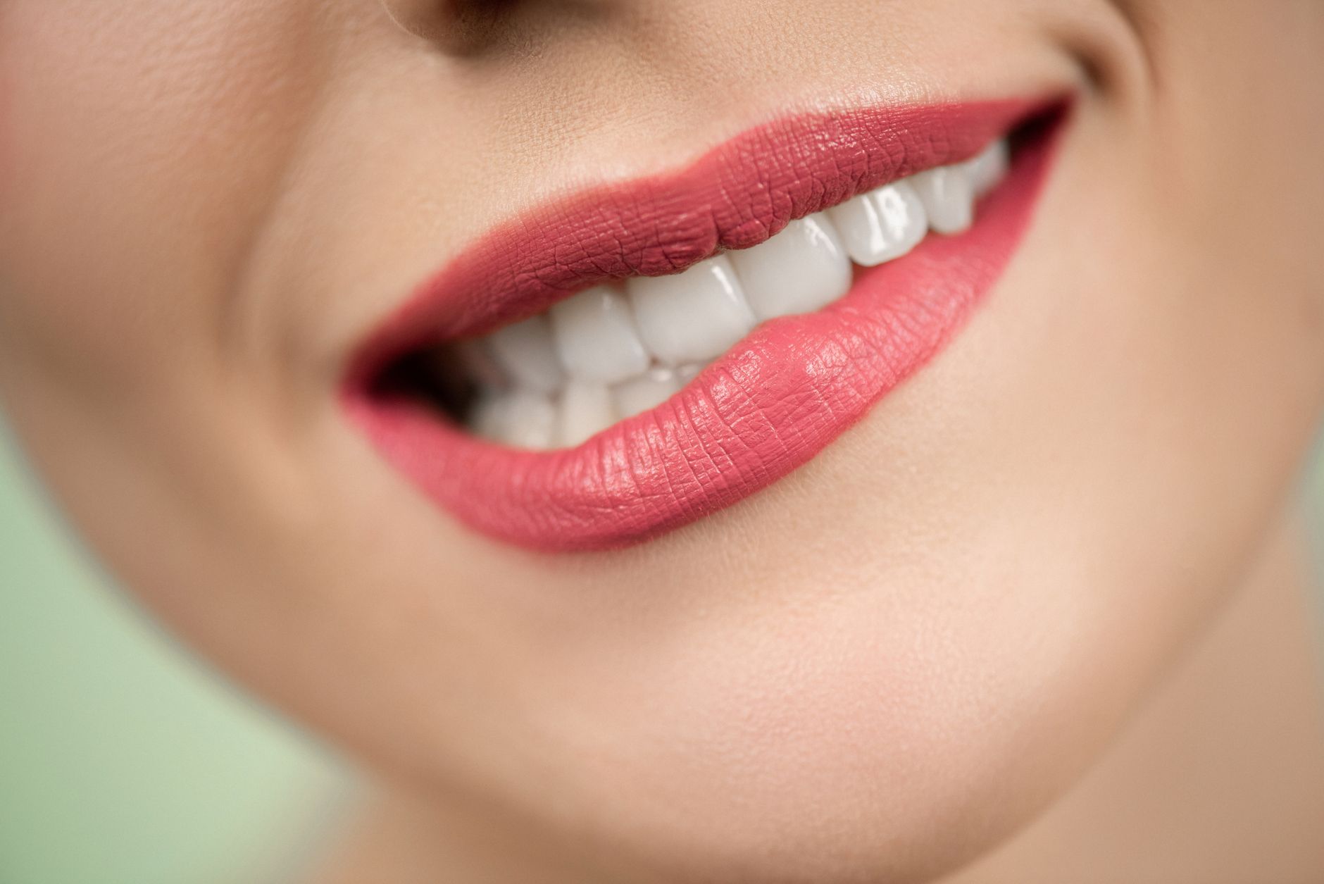Close-up shot of woman's mouth wearing red lipstick, highlig השתלת שיניים בכפר סבא